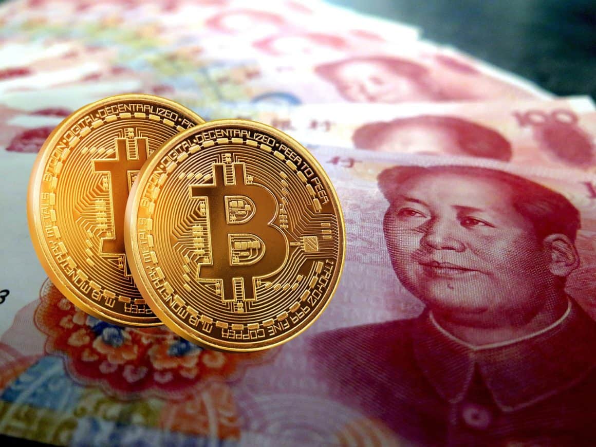 Bitcoins in front of 100 RMB bills