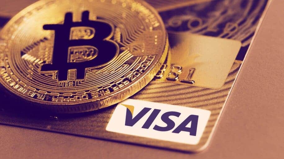 Visa card next to a golden Bitcoin