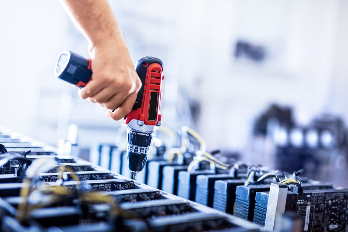 Assembling bitcoin mining machines. Man's hand screwing. Cryptocurrency farm. E-business.