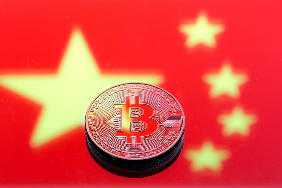 coins Bitcoin, against the background of the Chinese flag, concept of virtual money, close-up. Conceptual image of digital crypto currency.