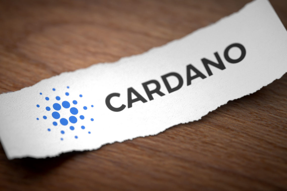 Image Description Cardano altcoin cryptocurrency logo printed on torn piece of scrap paper on wooden surface