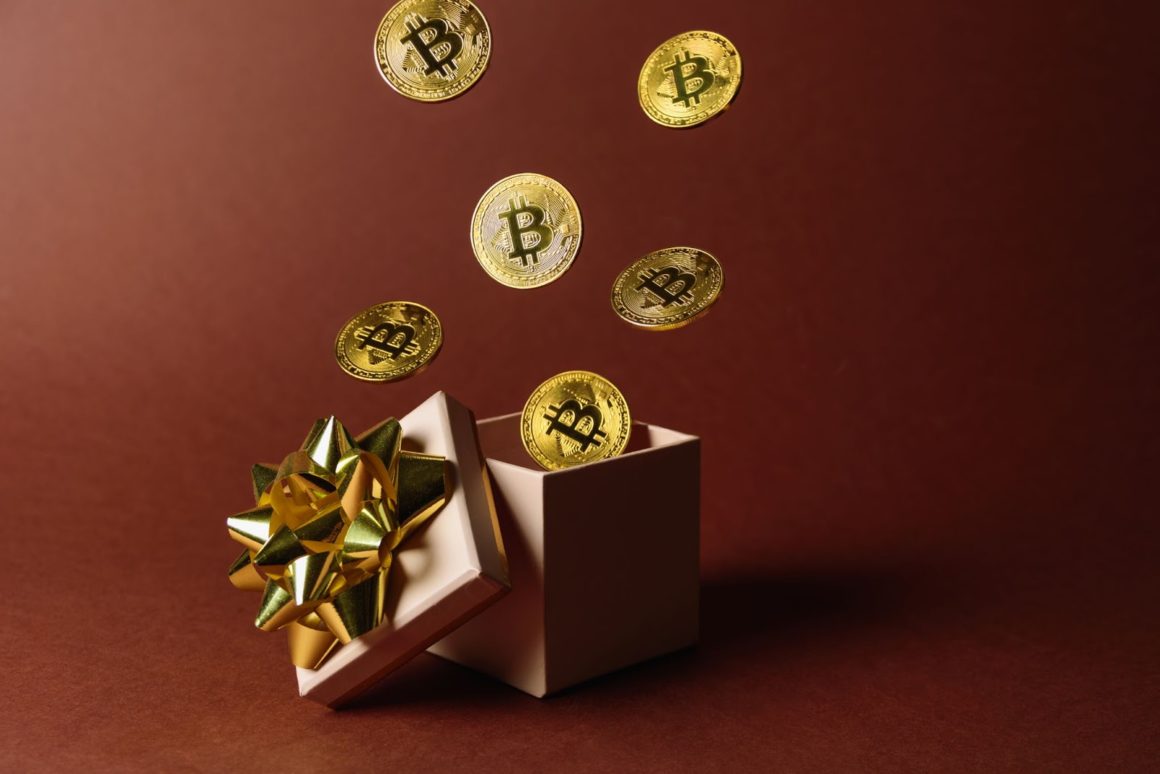 Physical Bitcoins flying out of a gift box