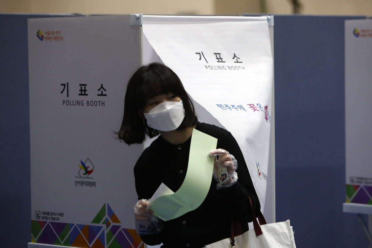 A South Korean woman wears a mask and plastic gloves cast her vote in a polling station on the Parliamentary election in 2020 | Crypto commitments are an election issue for South Korea’s presidential candidates