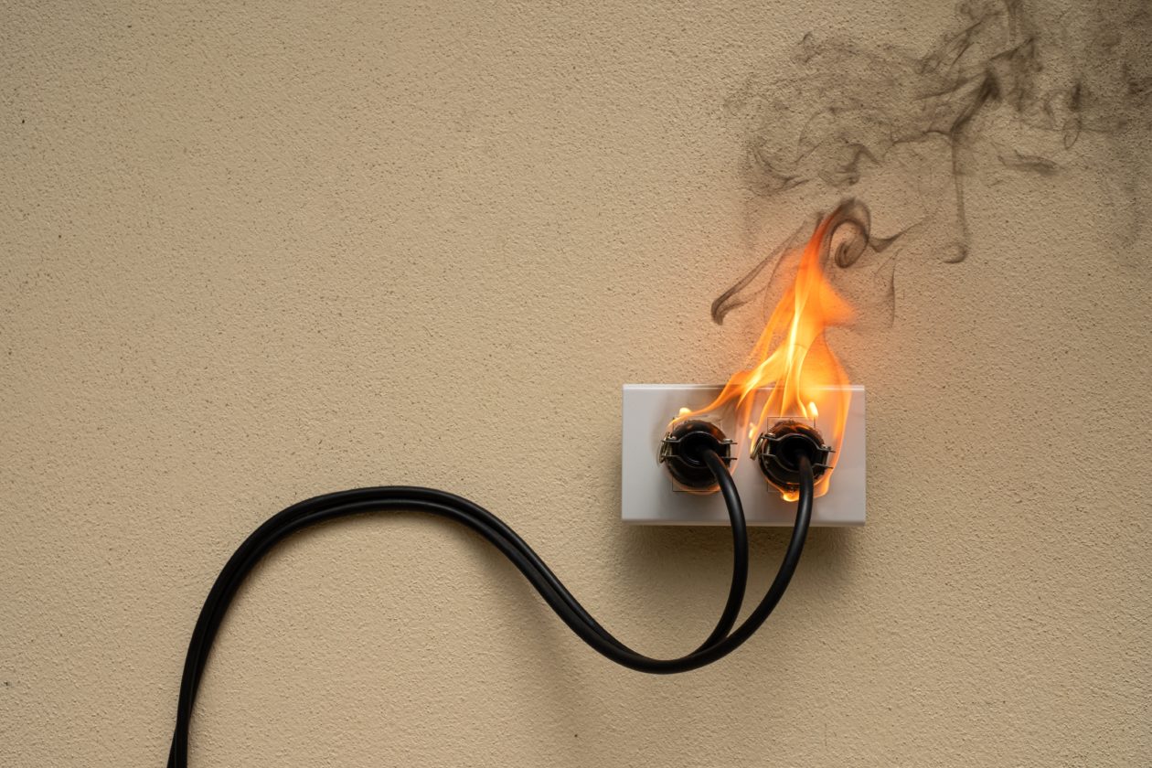 On fire electric wire plug Receptacle on the concrete wall backg