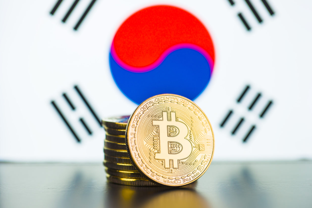 Physical models of Bitcoin crypto tokens in front of the South Korean flag