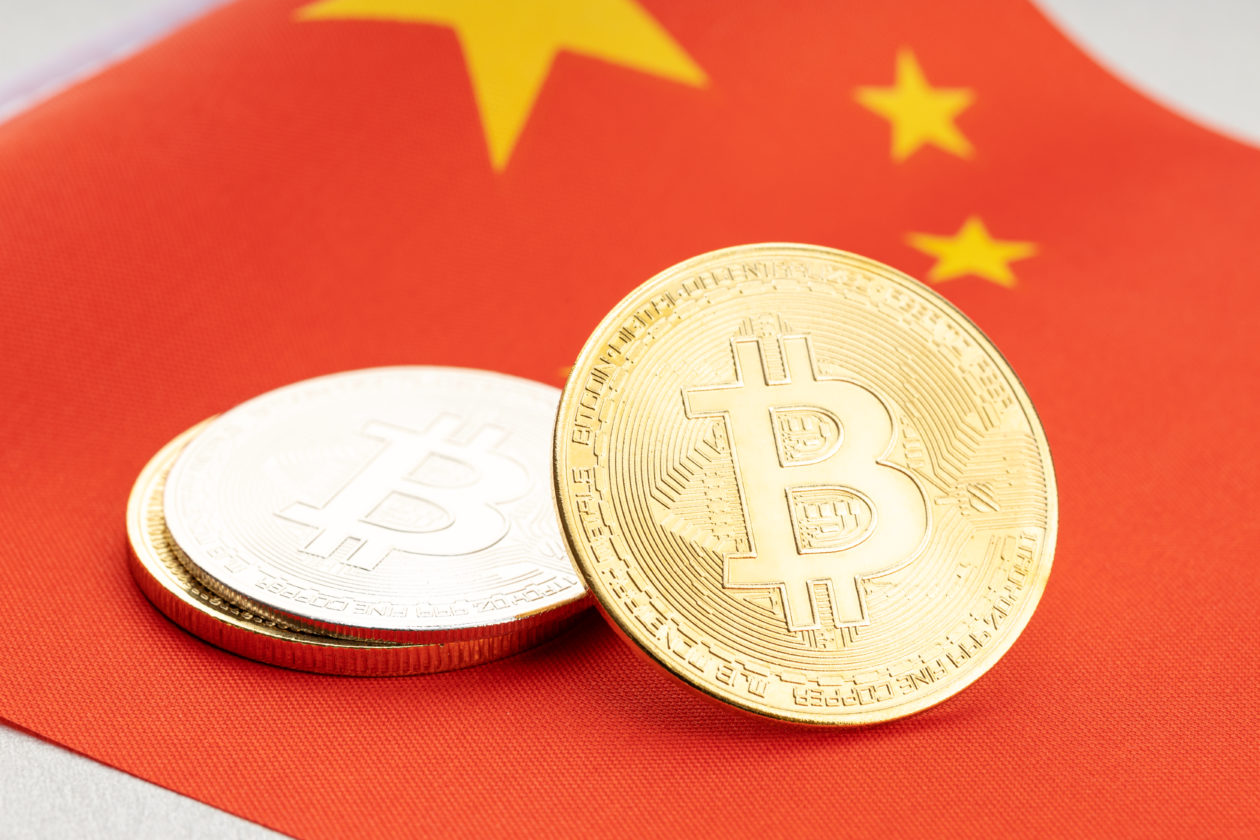 Bitcoin cryptocurrency coins on national flag of China. Crypto law regulation concept