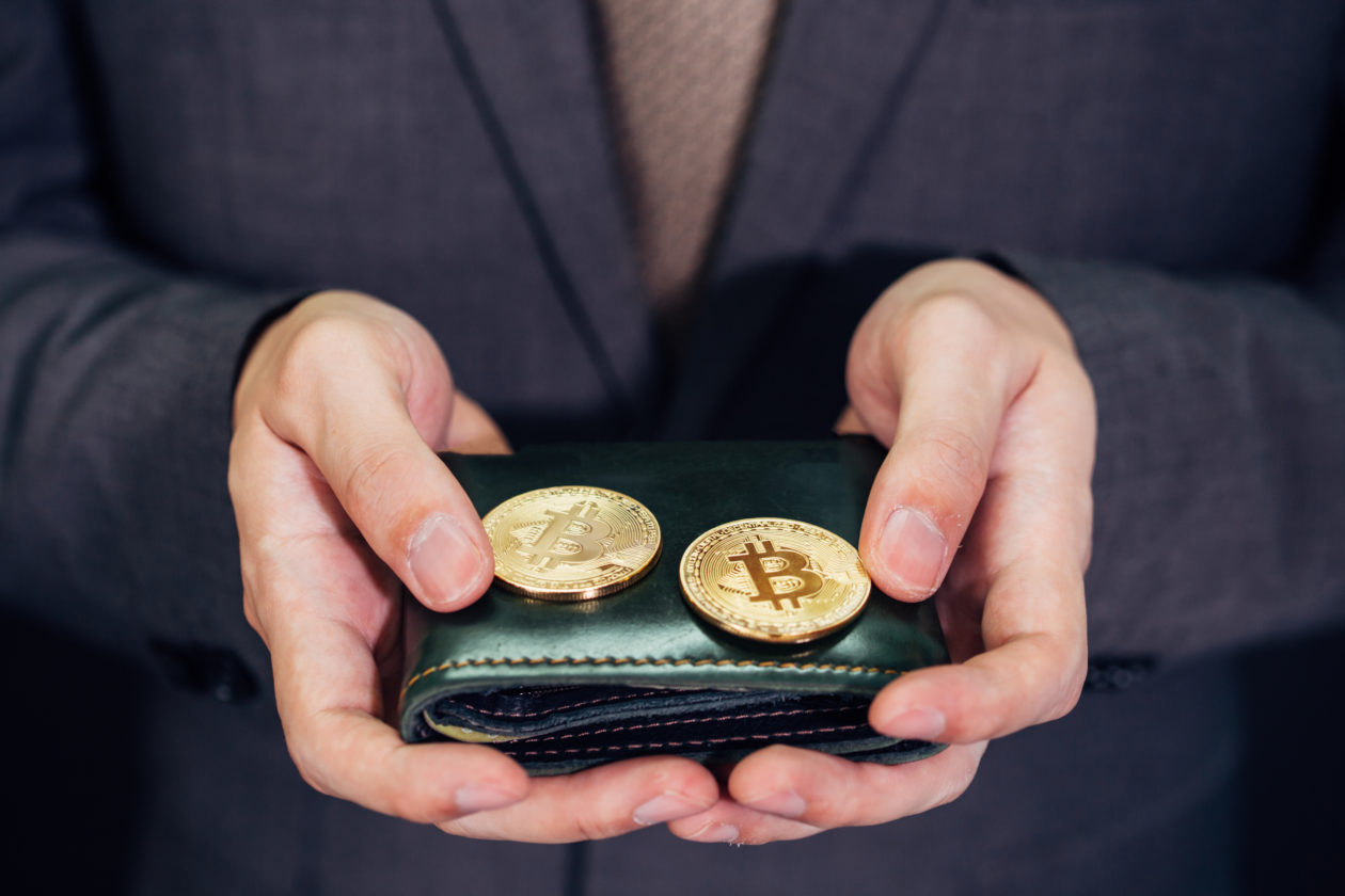 Close-up of businessman with wallet receiving and paying by bitcoin or cryptocurrency - crypto currency is the future of digital cashless financial banking trade | S.Korea tosses Travel Rule private wallets compliance to exchanges