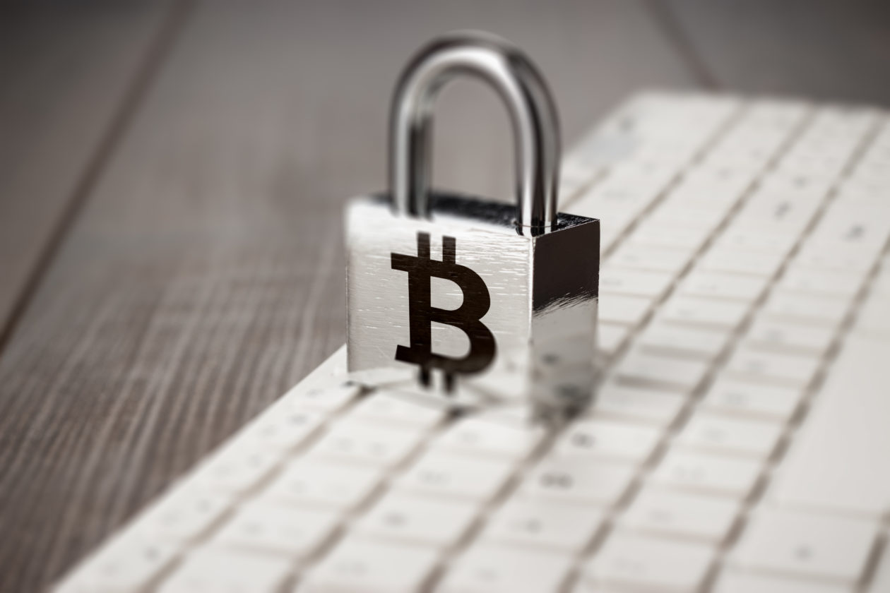 padlock with bitcoin symbol on white computer keyboard