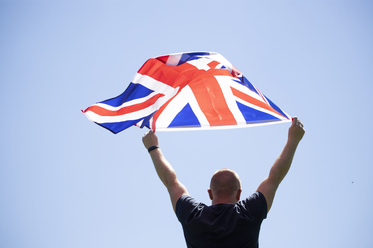 Patriot man holding the United Kingdom flag.