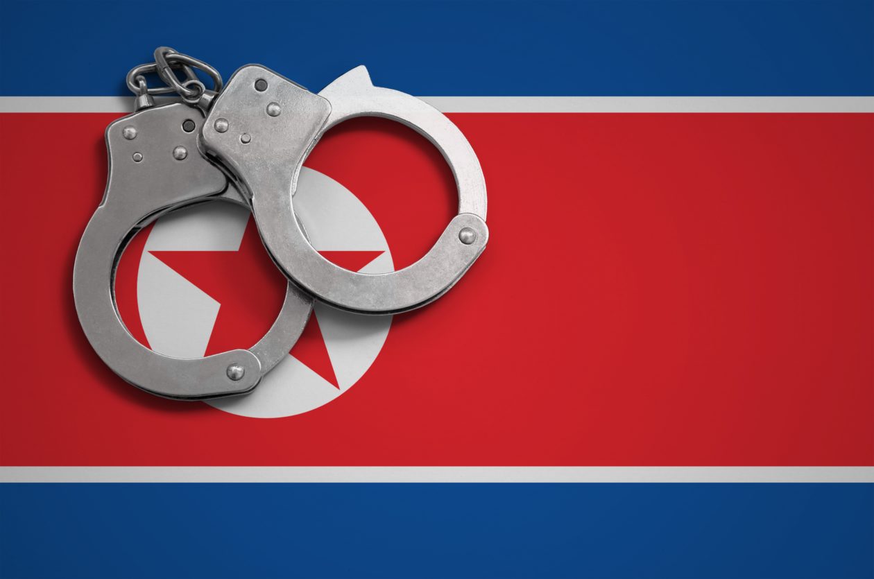 North Korea flag and police handcuffs. The concept of crime and offenses in the country