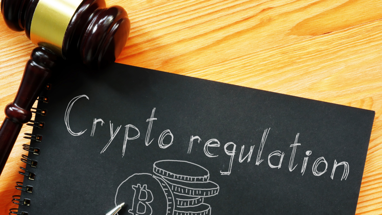 Judge gavel beside a drawing of Bitcoin on a paper with words crypto regulation