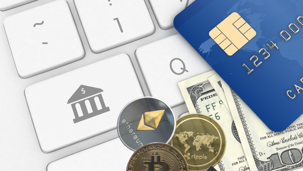 crypto coins, dollar bills, and credit card on top of keyboard