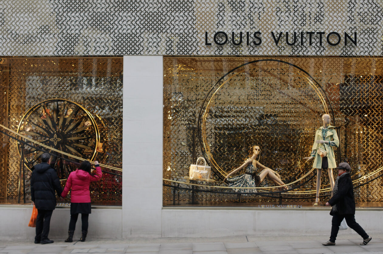People walk by the Louis Vuitton store on Bond Street in London, England
