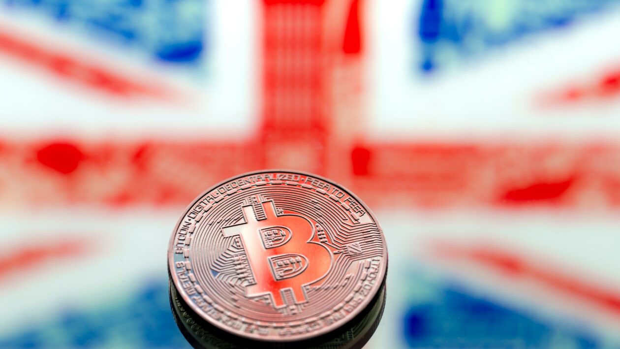 coins Bitcoin, on a background of Great Britain and the British flag, concept of virtual money, close-up. Conceptual image of digital crypto currency.