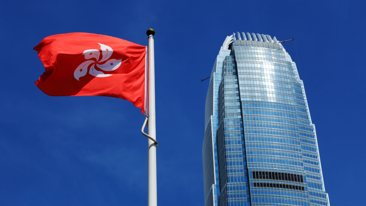 Hong Kong flag waving in front of a skyscraper