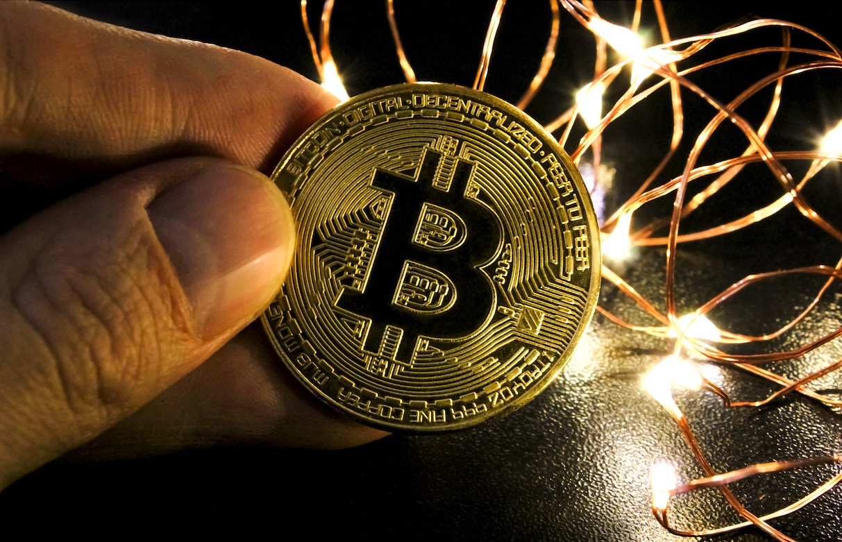 Mining bitcoin concept. Golden Bitcoin currency. Festive atmosphere on black background with lights.