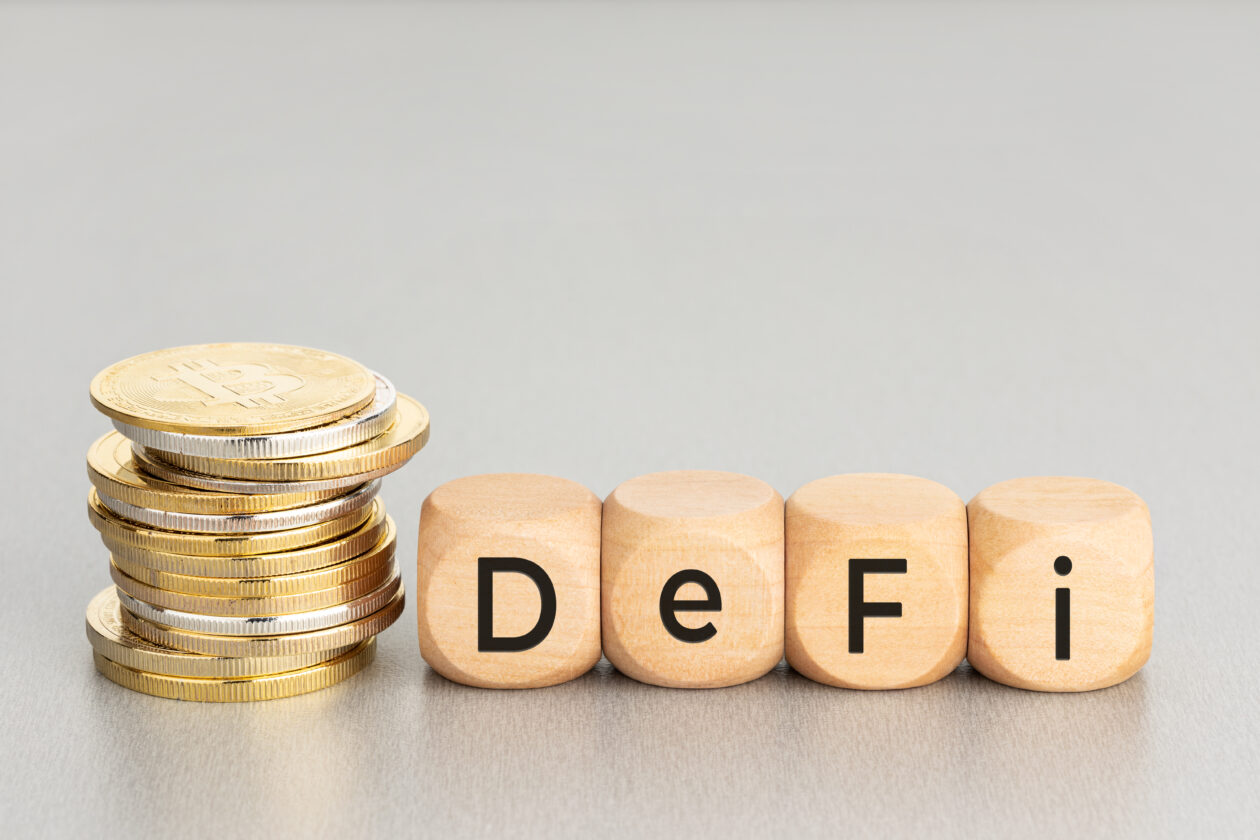 stacked crypto coins and wooden blocks with DEFi text