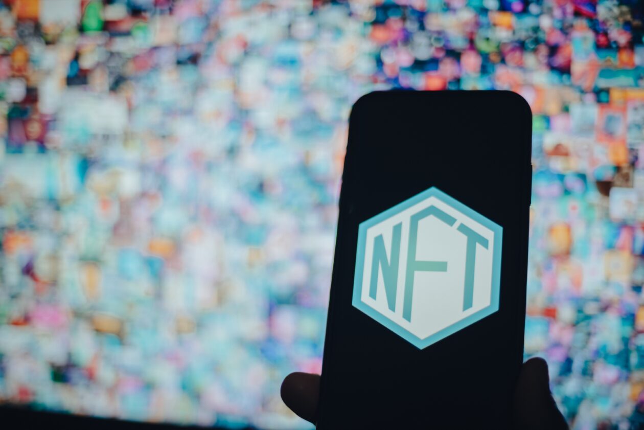 a-person-holding-a-mobile-phone-with-an-nft | Forkast 500 NFT Index slides, Polygon blockchain NFT sales jump nearly 250%