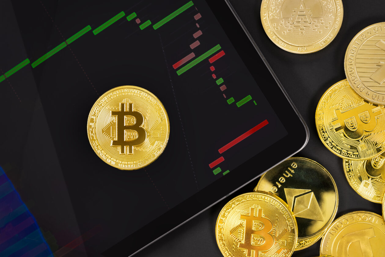 Bitcoin on digital tablet with exchange graph by crypto coins