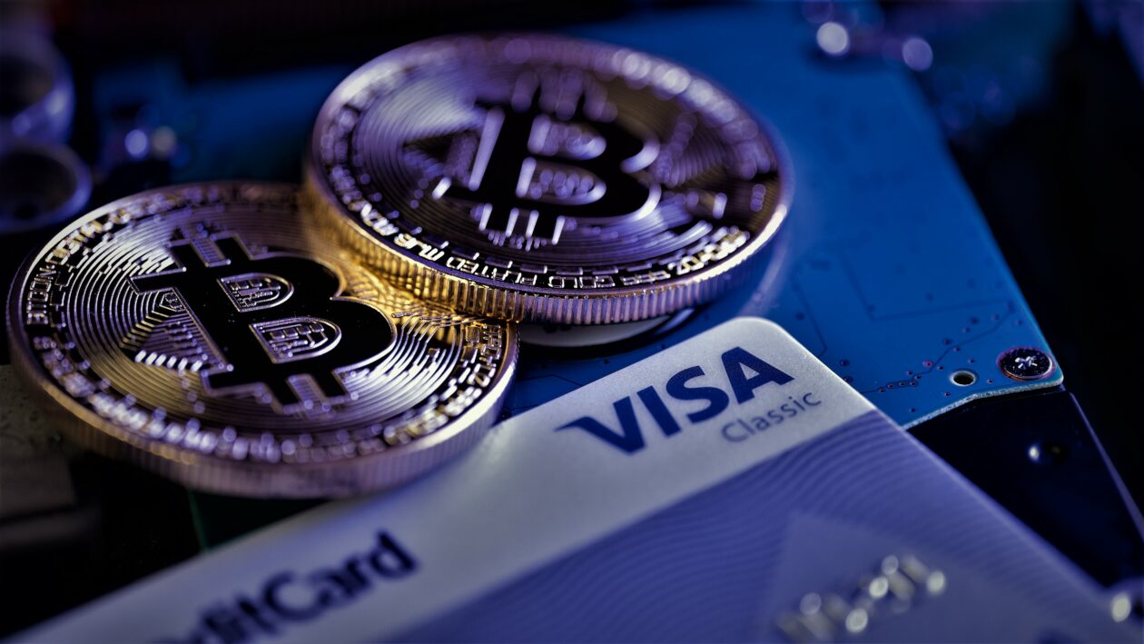 Golden coin with bitcoin symbol and Visa card, Visa not slowing down with crypto plans