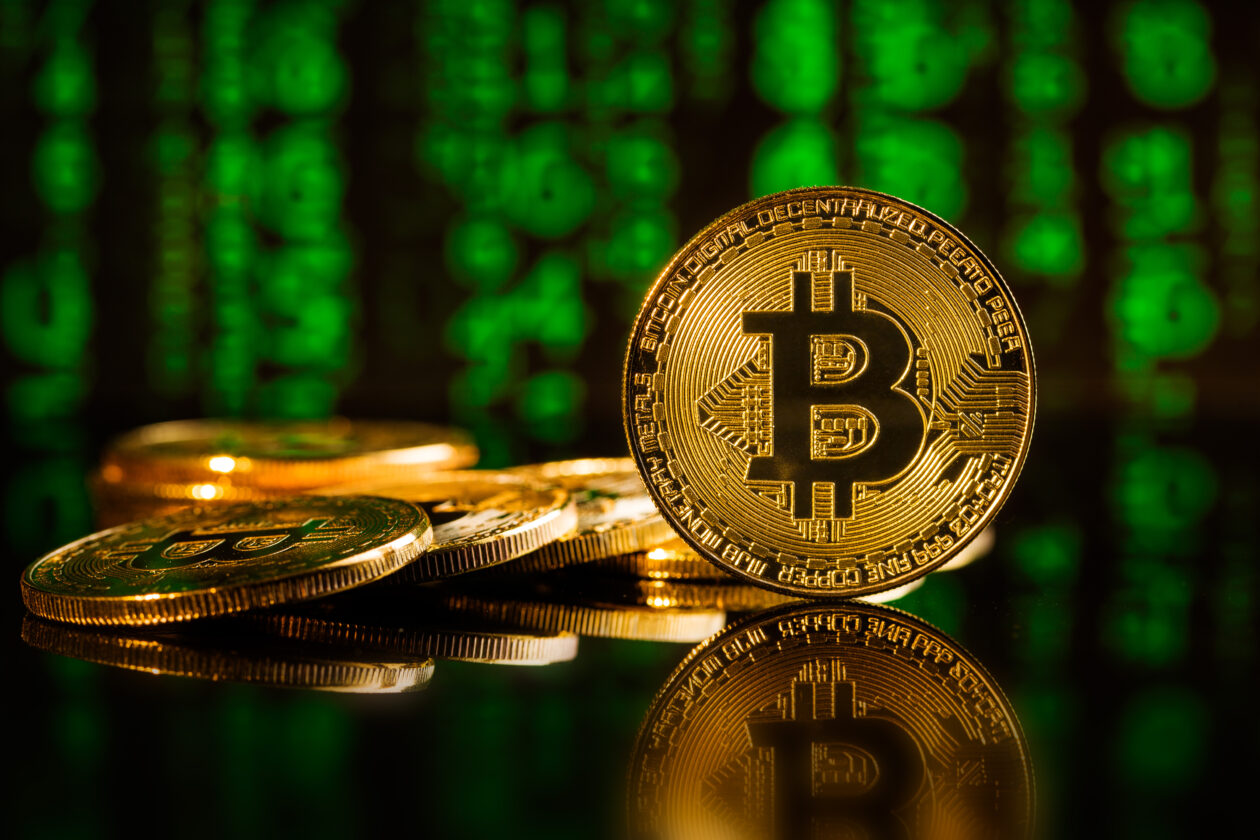 Golden bitcoins. Cryptocurrency in front of green matrix background.