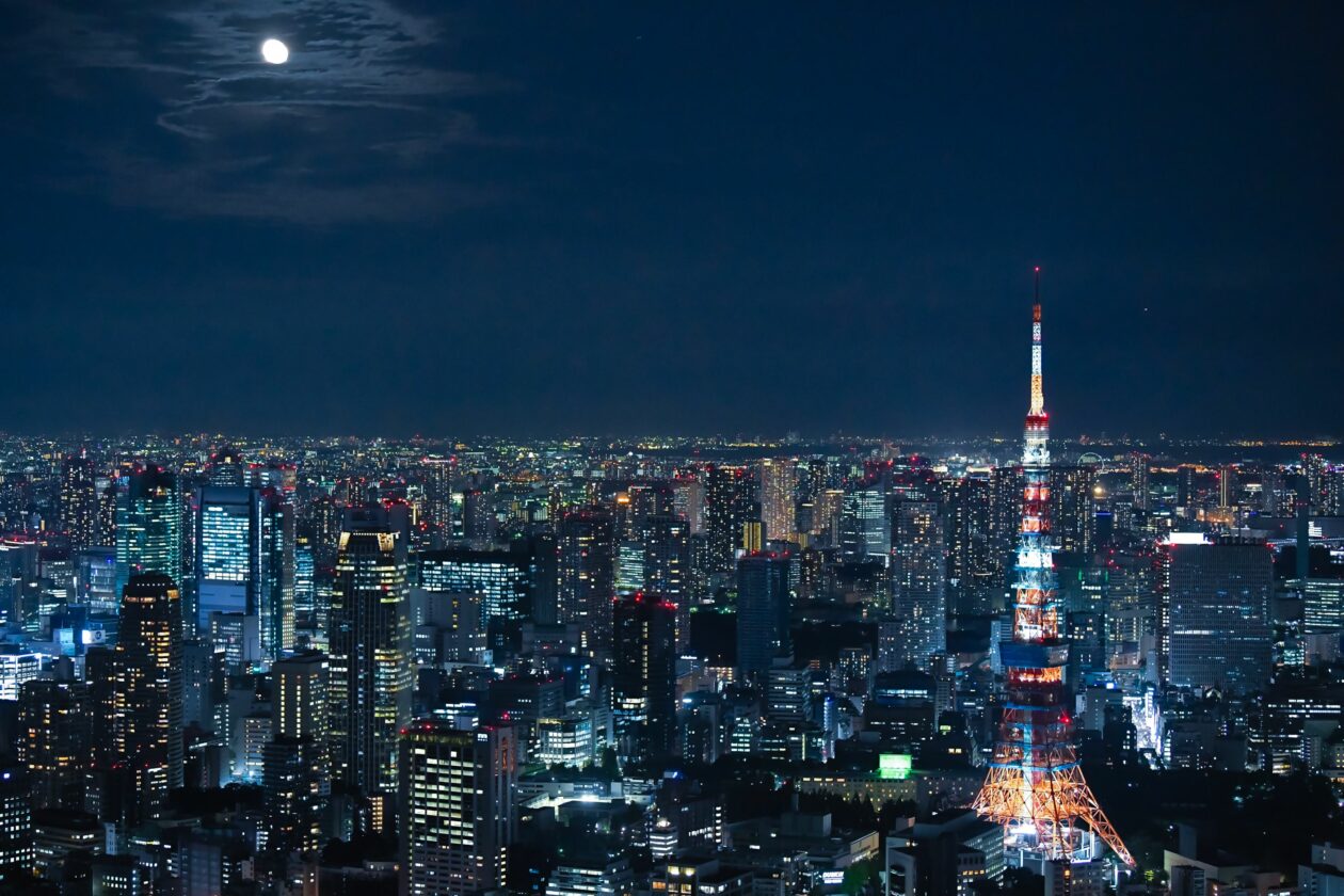 An aerial shot of Tokyo at night with luminous buildings and tall Tokyo TV tower | Japan exempts cryptocurrency issuers from 30% tax on unrealized gains