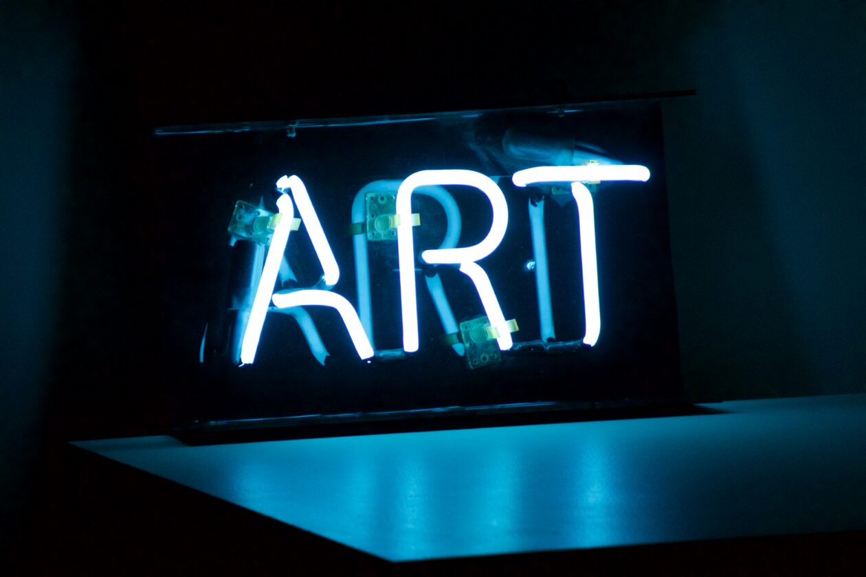 Blue and white neon sign spelling "ART"