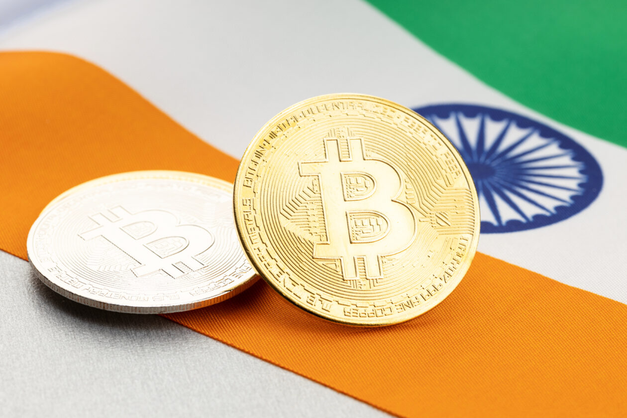 Bitcoin cryptocurrency coins on national flag of India. Crypto law regulation concept