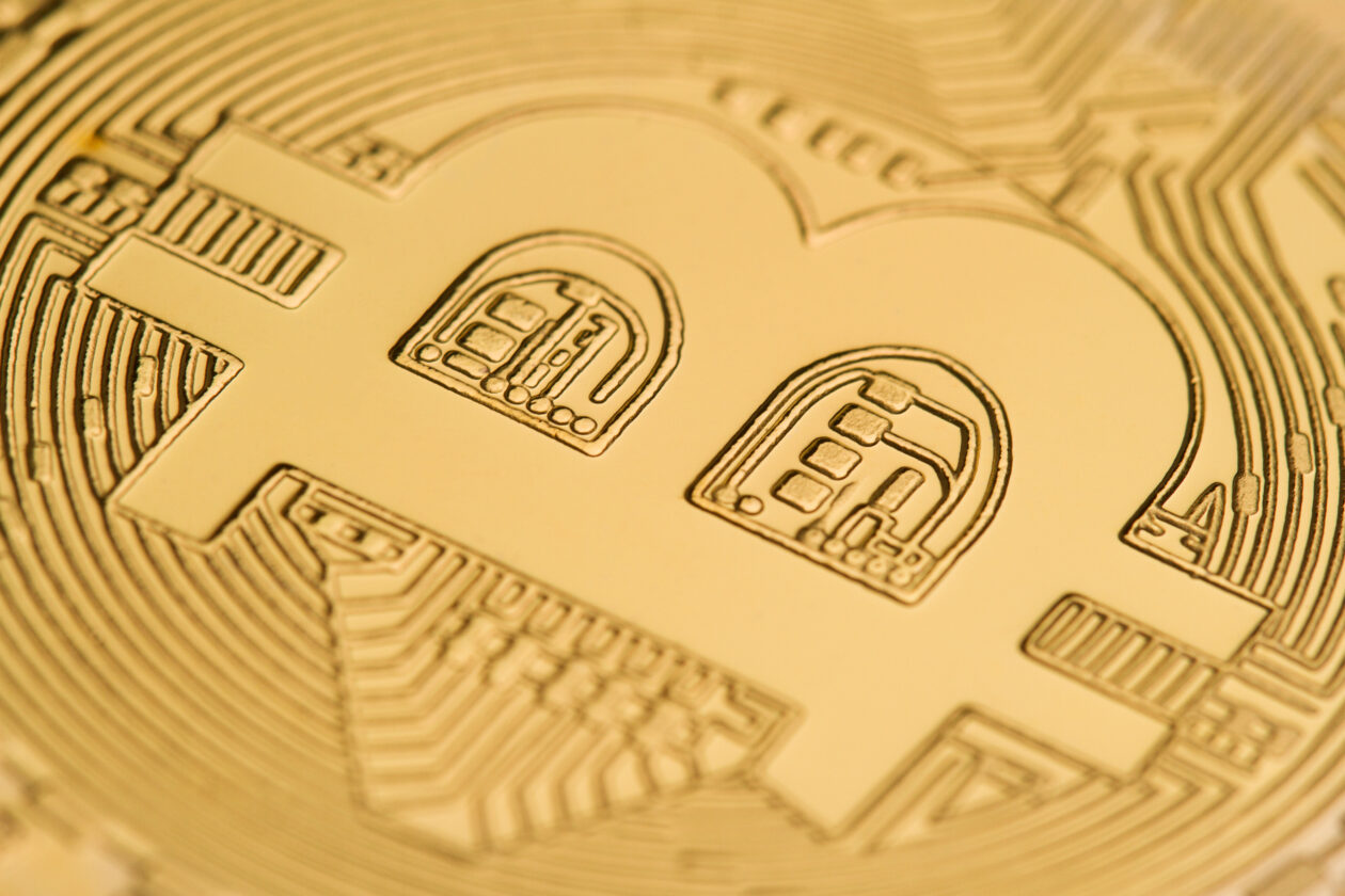 horizontal top view close up of bitcoin logo on a golden coin