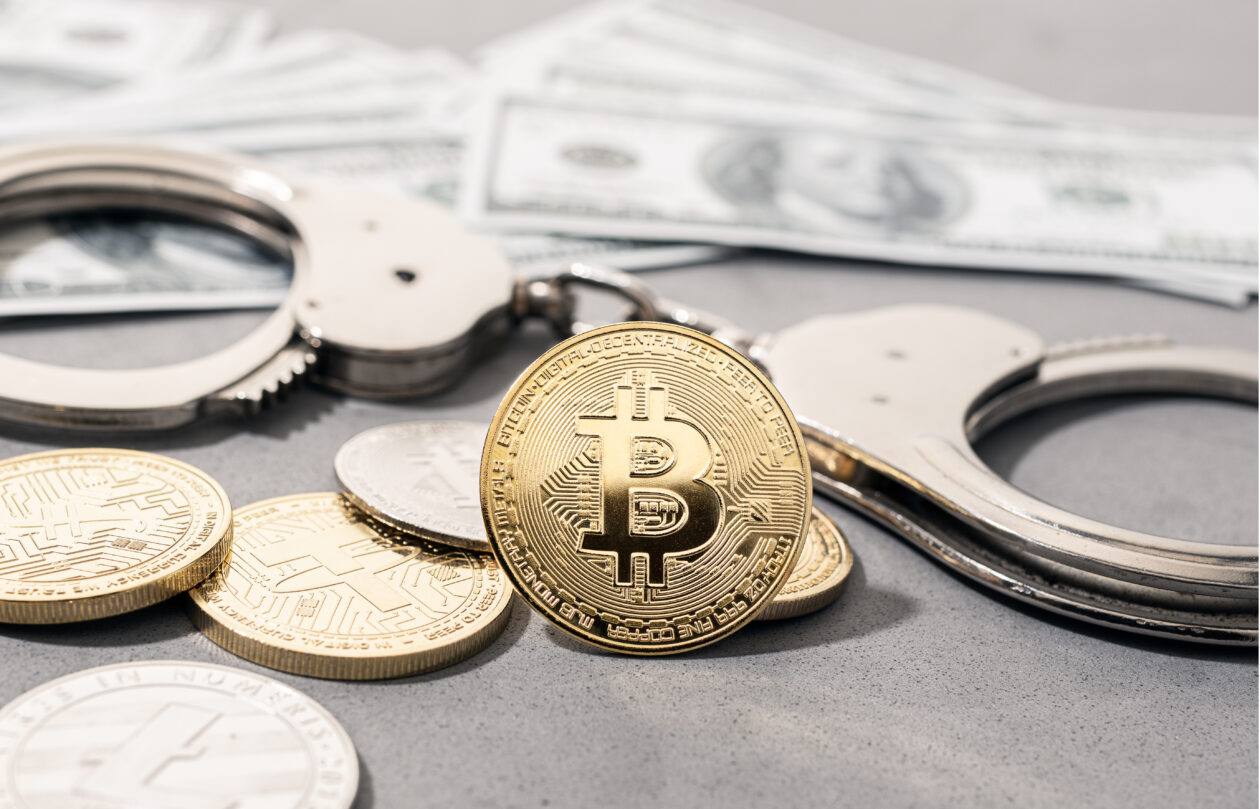 Crypto crime fraud concept. Bitcoin and crypto coins, handcuffs and US dollar banknotes
