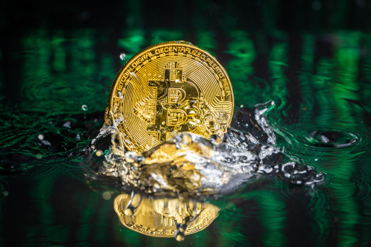 Gold bitcoin coin falling to water. Bitcoin and water splash. Cryptos decline on the back of Wall Street losses and Fed speculation